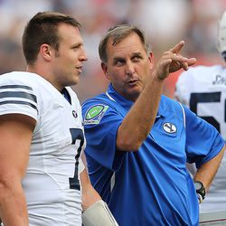 BYU Offensive coordinator Ty Detmer talks with Brigham Young Cougars quarterback Taysom Hill (7) as they wait for a ruling at the end of the first half as they play West Virginia at FedEx Field in Landover, Maryland on Saturday, Sept. 24, 2016. 