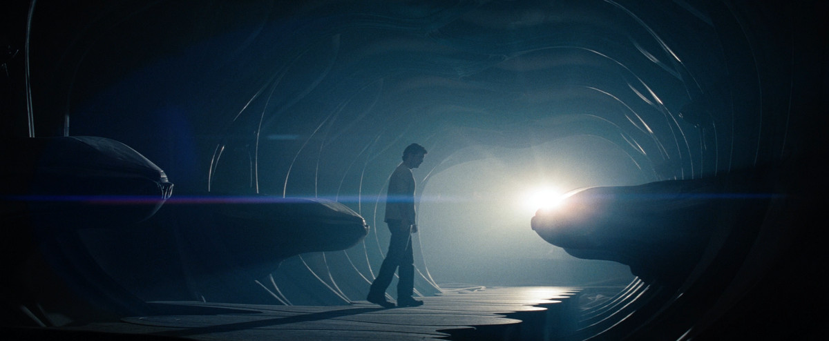 Henry Cavill as Clark Kent stands in a Kryptonian ship, with odd alien objects around him and a light in the background, in Man of Steel