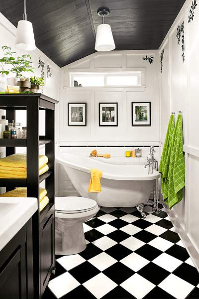 Small bathroom with checkerboard floor and subtle monochromatic prints on the top of the walls. 