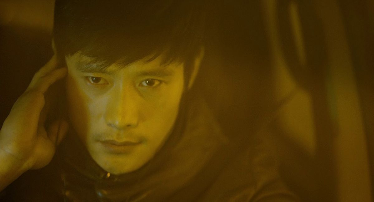 Lee Byung-hun holds his right hand to his ear and looks very serious in I Saw the Devil.