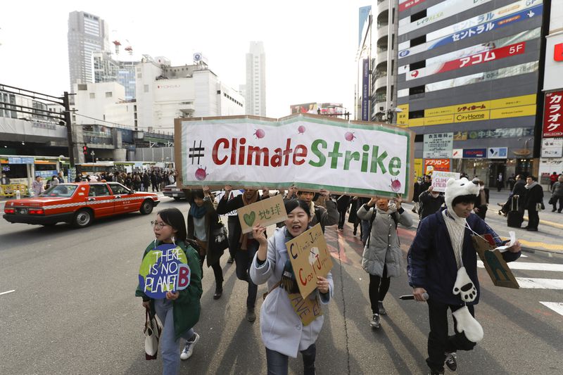 Participants hold signs and shout slogans during the Fridays for Future march on March 15, 2019 in Tokyo, Japan. 