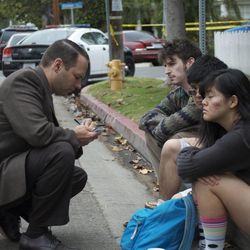 A detective interviews Santa Monica College students Friday June 7, 2013 in Santa Monica, Calif., after a gunman with an assault-style rifle killed at least six people in Santa Monica before police shot him to death in a gunfight in the school's library, authorities said. 