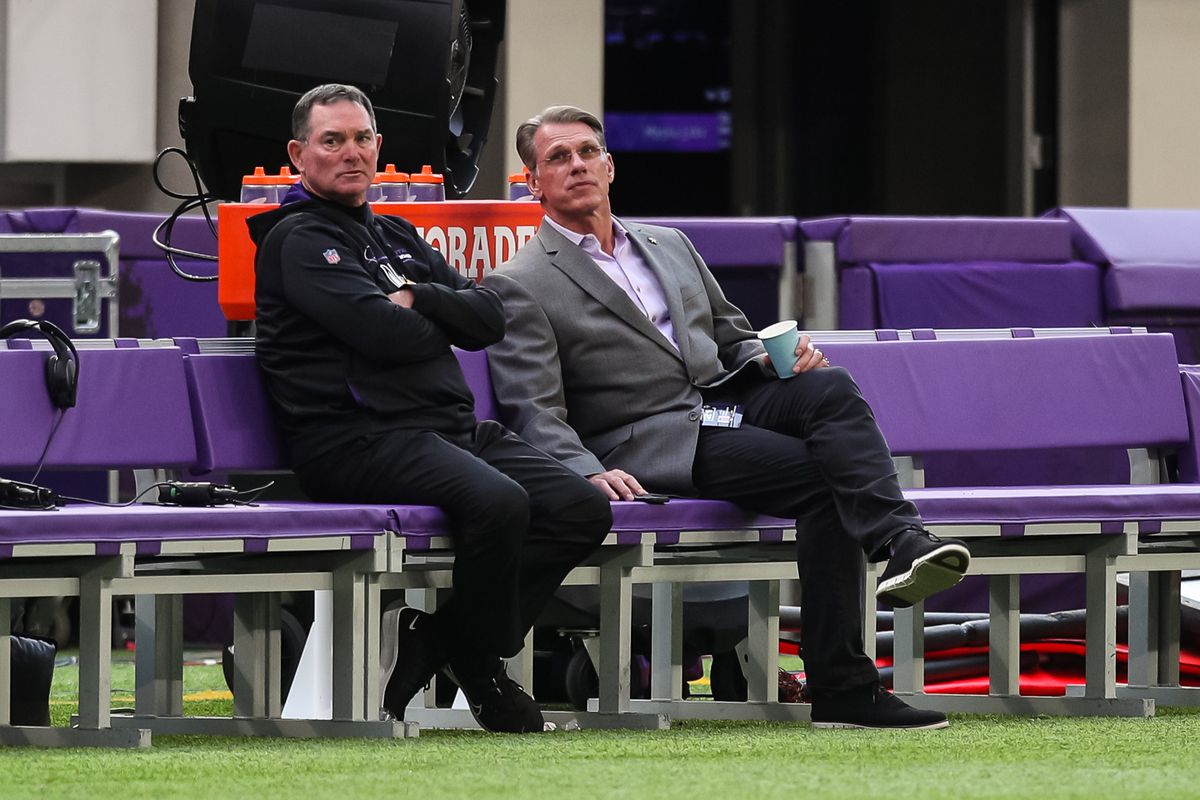 Head coach Mike Zimmer of the Minnesota Vikings, left, and general manager Rick Spielman talks before the start of a preseason game against the Indianapolis Colts at U.S. Bank Stadium on August 21, 2021 in Minneapolis, Minnesota.