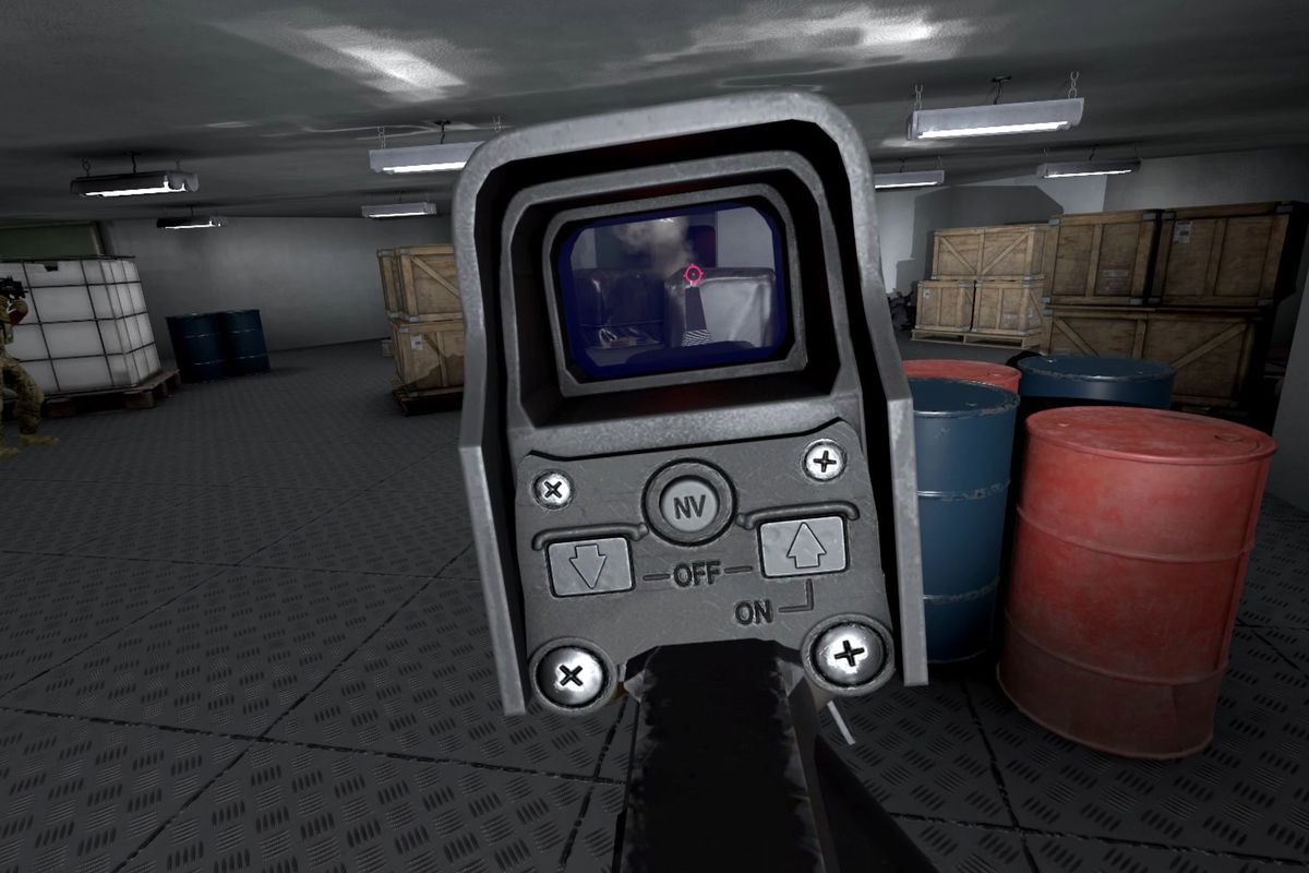 The view through a holographic sight in Onward, a VR first-person shooter from Downpour Interactive. The player is standing in the bowels of a container ship, with drums of fuel and potable water as well as wooden crates for cover. The decking below is ma