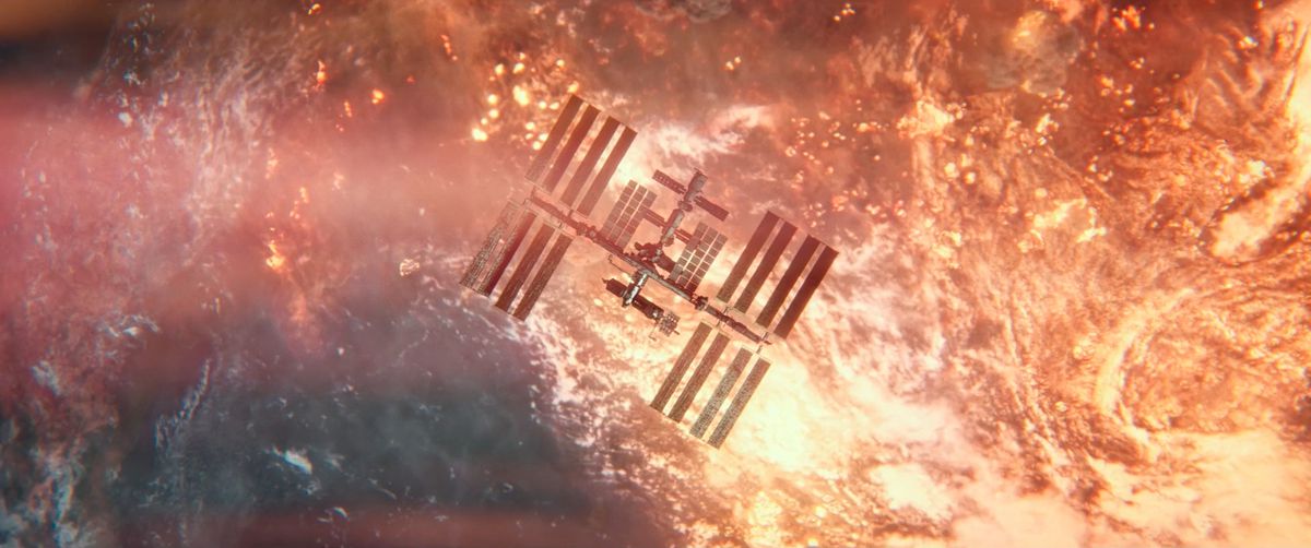 The International Space Station floats in orbit, silhouetted against a burning, vividly orange post-nuclear-war Earth in I.S.S.