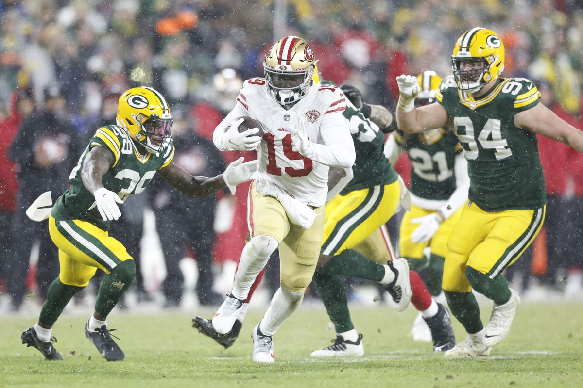 San Francisco 49ers wide receiver Deebo Samuel (19) carries the ball past Green Bay Packers defensive end Dean Lowry (94) and Packers defensive back Chandon Sullivan (39) in the third quarter during a NFC Divisional playoff football game at Lambeau Field.