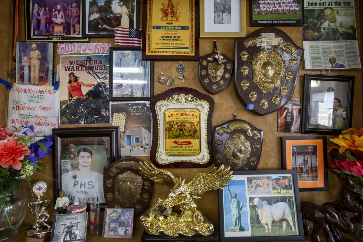 A jumble of plaques, framed photos, and other ephemera on a wall.