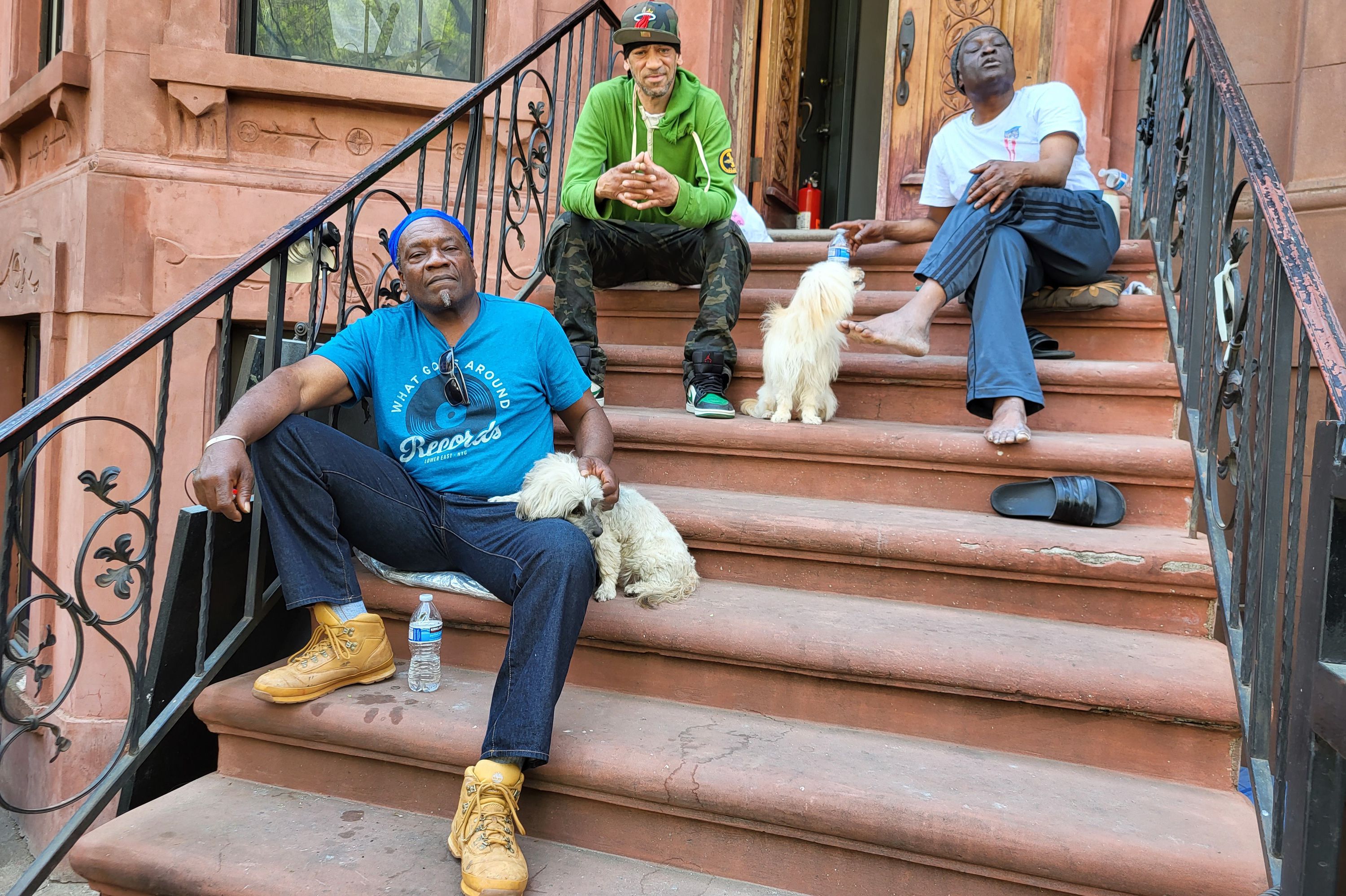 Harlem residents Keith Woody, Alstin Francis and former neighbor, Rickey Colbourne, sit on a Brownstone stoop next to the Langston Hughes House.