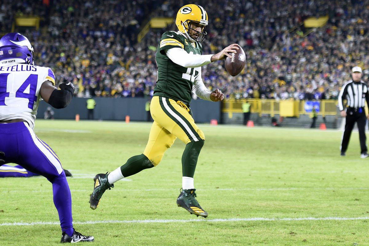 Aaron Rodgers of the Green Bay Packers runs for a two yard touchdown during the fourth quarter Minnesota Vikings at Lambeau Field on January 01, 2023 in Green Bay, Wisconsin.