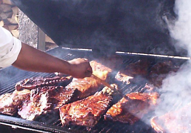 Several large hunks of meat roasting on a barbecue