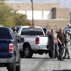 Las Vegas Metro Police officers and FBI agents stand in the street after a stand-off in Las Vegas Thursday, Feb. 19, 2015. Police arrested a man suspected of being involved in the road rage shooting of 44-year-old Tammy Meyers last week. 