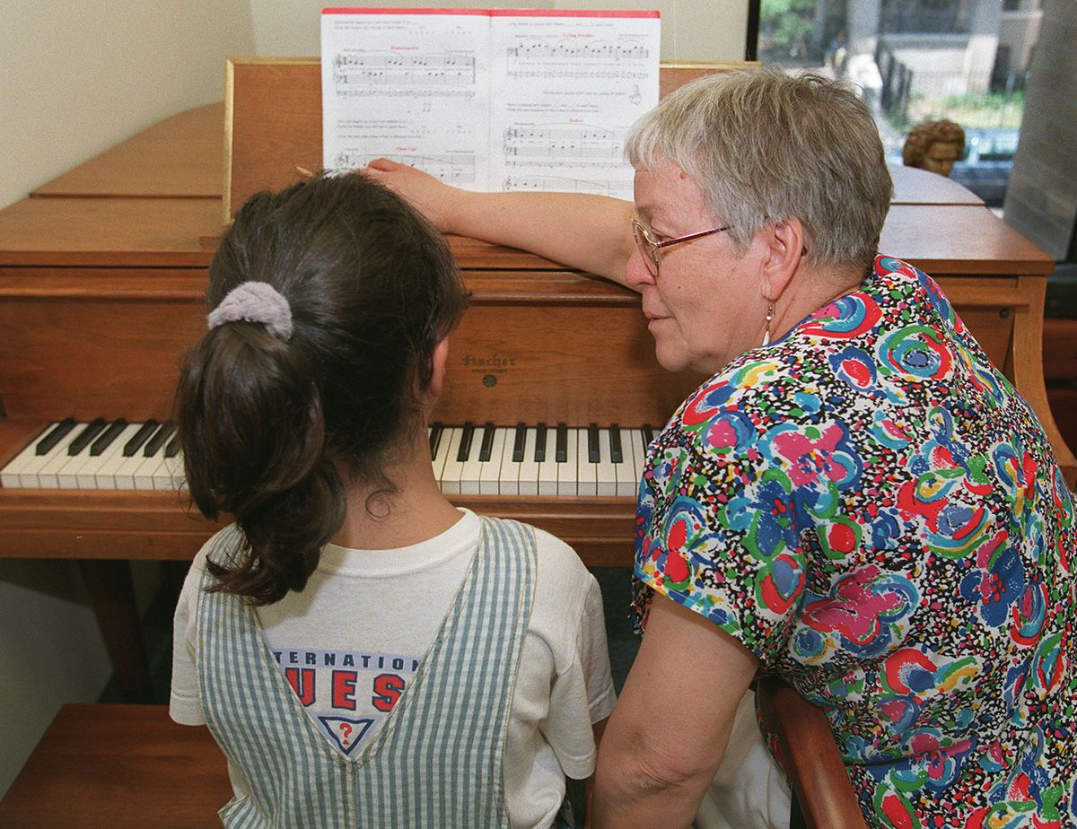 Rita Simó, founder of the Peoples Music School, giving piano lessons to Michelle Khoshaba, 7.