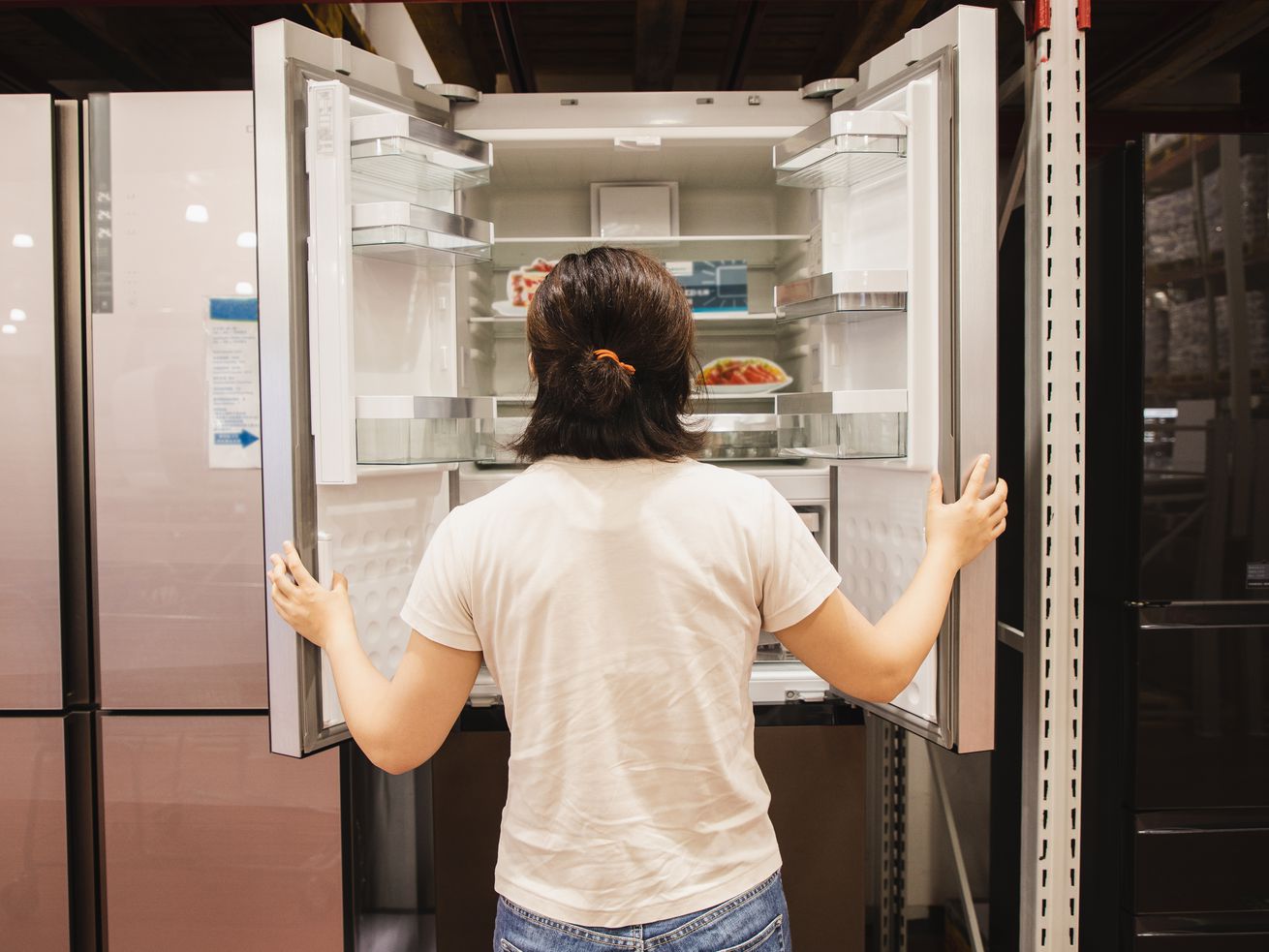 A person opening a refrigerator.