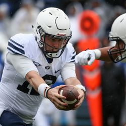 Quarterback Tanner Mangum hands off the ball during the BYU football spring practice and scrimmage at LaVell Edwards Stadium in Provo on Saturday, March 25, 2017.
