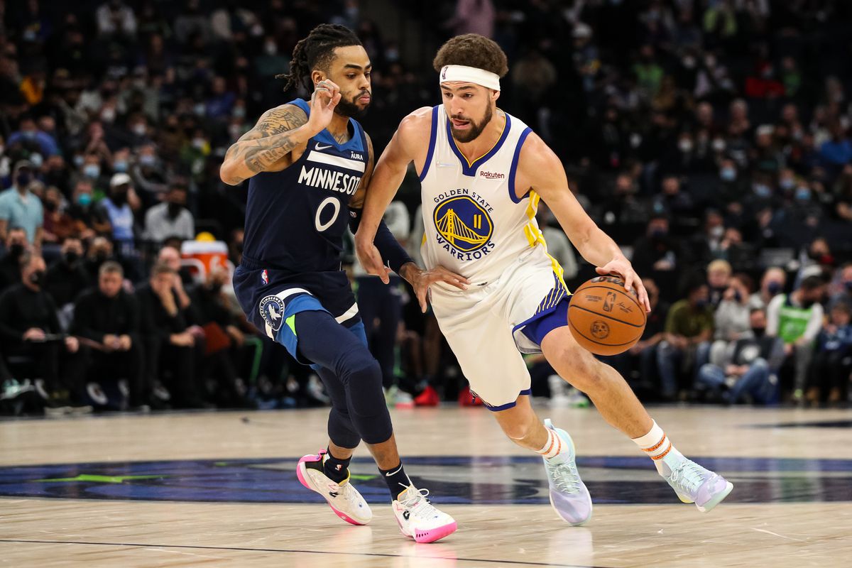 Warriors guard Klay Thompson dribbles past Timberwolves guard D’Angelo Russell