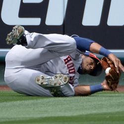 Houston Astros right fielder Jimmy Paredes role over after making a catch on a ball hit by Los Angeles Angels' Josh Hamilton during the sixth inning of the MLB American League baseball baseball game, Sunday, June 2, 2013, in Anaheim, Calif.  