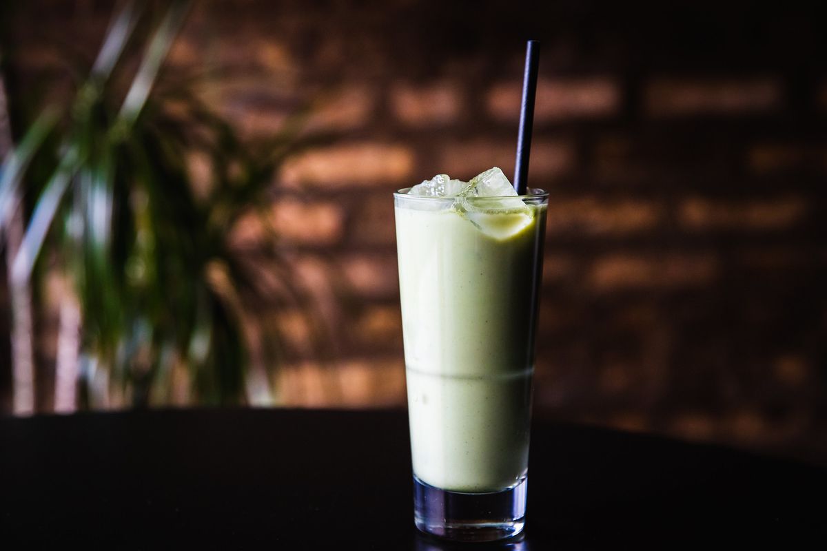 Seeing Green: milky light green liquid in a highball glass with ice and a straw