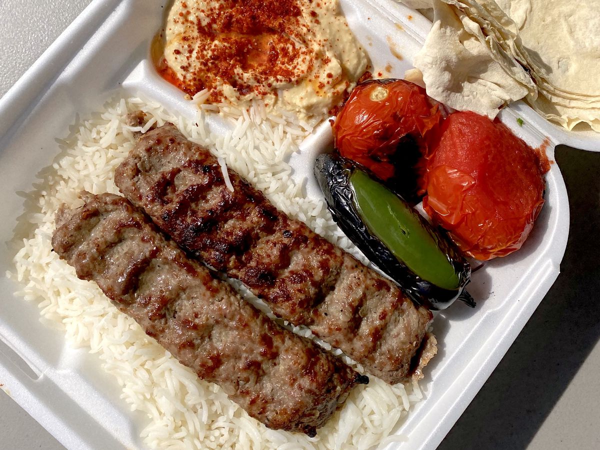 A styrofoam container filled with koobideh, hummus, and roasted vegetables from Mini Kabob in Glendale.