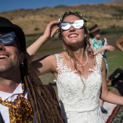 Liam Dorney, of Brisbane, Australia, left, and Elien Wijns, of Brussels, Belgium, take in the early stages of the total solar eclipse at Mann Creek Reservoir near Weiser, Idaho, on their wedding day, Monday, Aug. 21, 2017. The couple met while viewing a total solar eclipse in Australia, got engaged while viewing another total solar eclipse in the Faroe Islands and have since seen another in Indonesia. The couple wed later Monday after viewing this latest total solar eclipse with family and friends.
