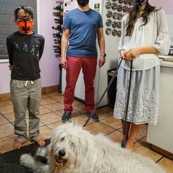 Max Weidmann, 10, left, Rob Weidmann, Sophie Weidmann, 13, and their dog Frigga pose for a photograph with their air pollution masks on at their home in Salt Lake City on Thursday, Nov. 8, 2018.