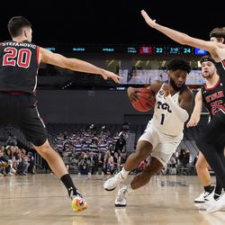 TCU guard Mike Miles (1) drives to the basket as Utah’s Lazar Stefanovic (20), Rollie Worster (25) and Branden Carlson, right, defend in the first half of an NCAA college basketball game in Fort Worth, Texas, Wednesday, Dec. 8, 2021. 