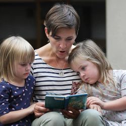 Susanna Risser reads to her daughters Coco and Josie at the Salt Lake Main Library in Salt Lake City Friday, Aug. 29, 2014.