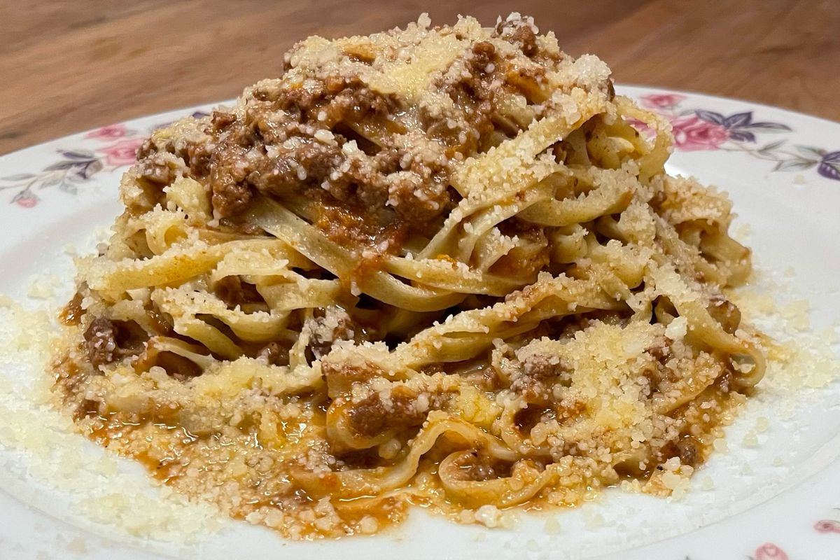 A plate of pasta sprinkled with cheese.