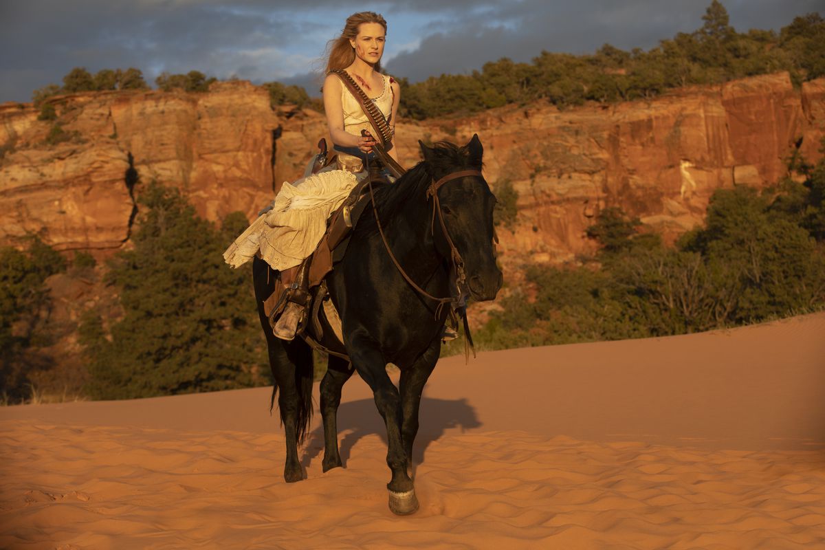 Evan Rachel Wood riding a horse in a rocky lanscape. 