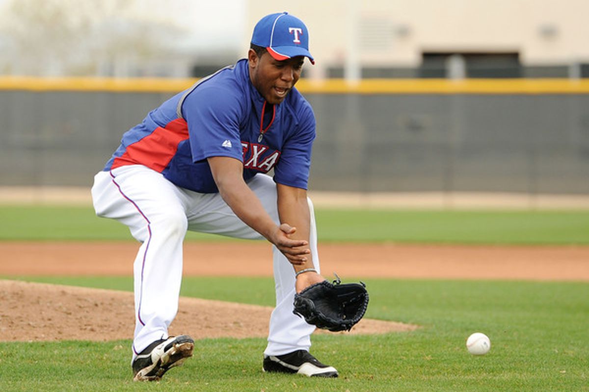 SURPRISE AZ - FEBRUARY 18:  Neftali Feliz #30 of the Texas Rangers fields a ground ball at Surprise Stadium on February 18 2011 in Surprise Arizona.  (Photo by Norm Hall/Getty Images)