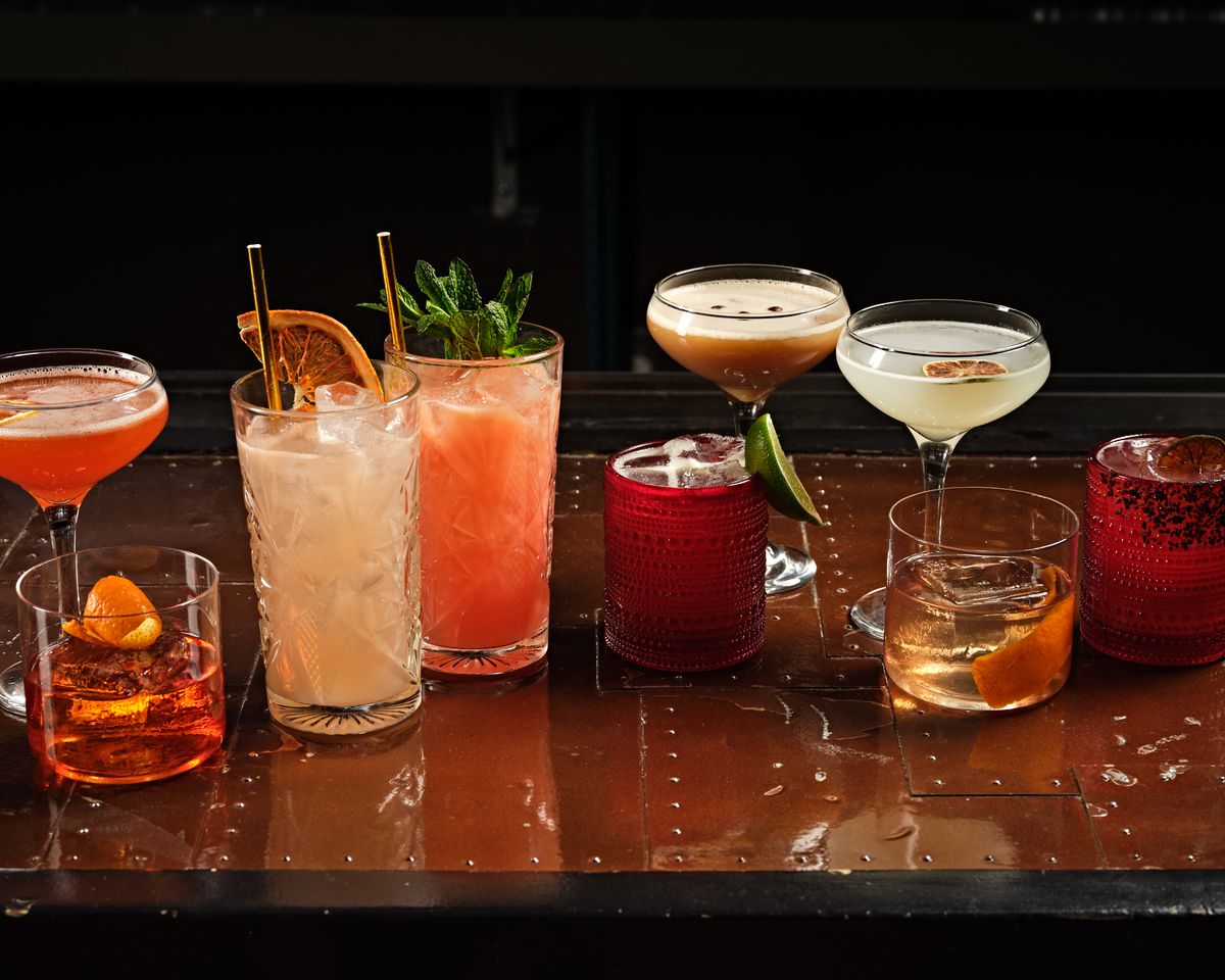 A long, wide shot of cocktails in different glass styles at a new bar.