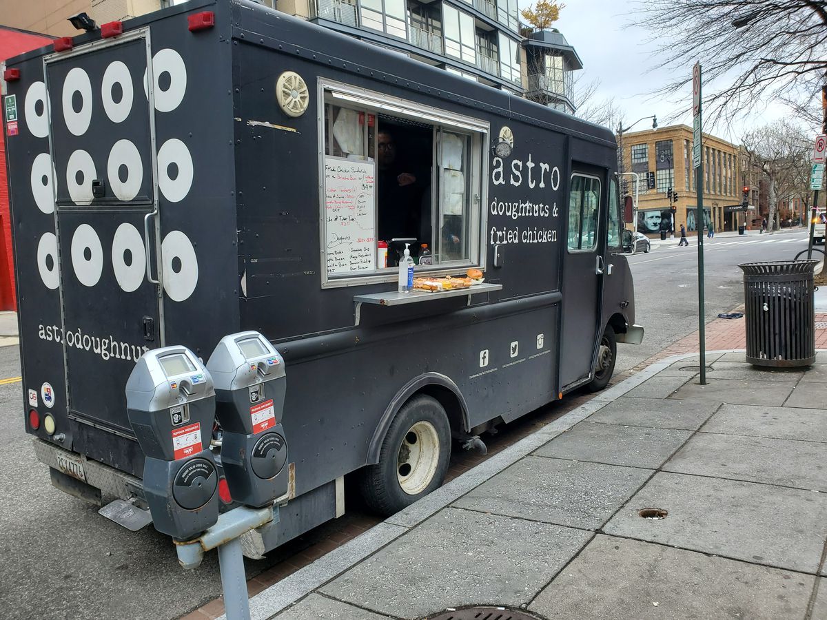 The Astro Doughnuts &amp; Fried Chicken truck offers pumps of hand sanitizer to prospective customers in Logan Circle
