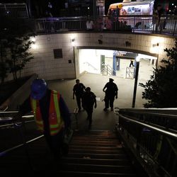 Police officers stand at the entrance to a closed subway station during a power outage Saturday, July 13, 2019, in New York. (AP Photo/Michael Owens)