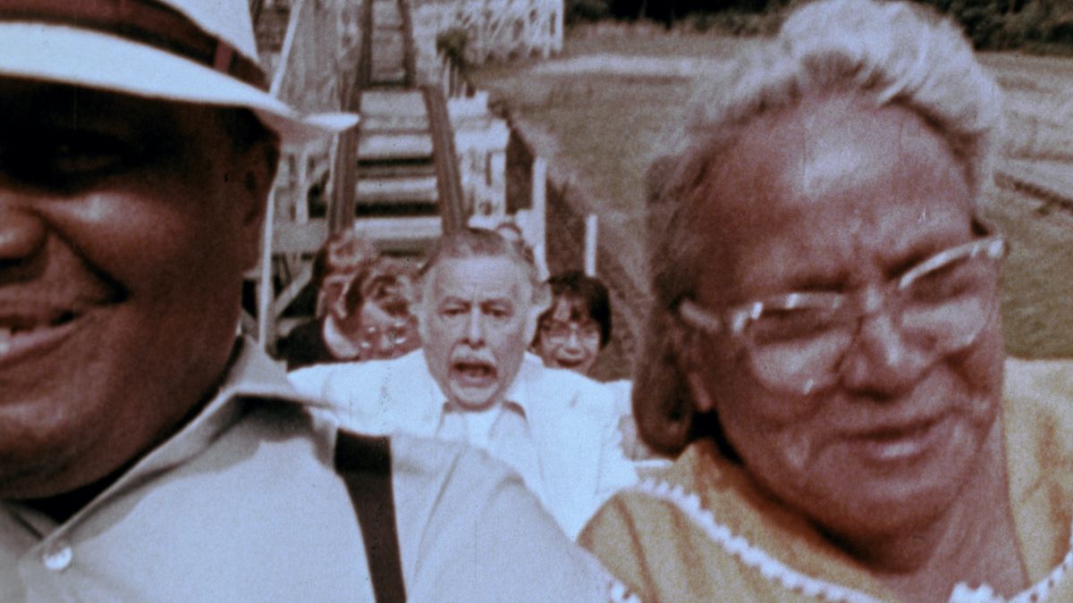 An elderly man in a black suit screams while riding a roller coaster in George A. Romero’s The Amusement Park