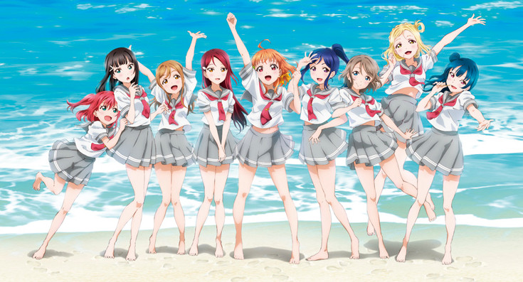 Nine girls cheer on a beach in front of the ocean
