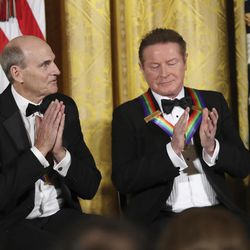 Recipients of the 2016 Kennedy Center Honors musician James Taylor, left, with fellow recipient, Don Henley, a member of the rock band the Eagles, gestures as he is recognized during a reception in their honor in the East Room of the White House in Washington, Sunday, Dec. 4, 2016, hosted by President Barack Obama and first lady Michelle Obama. 