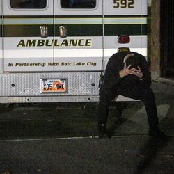 An EMT sits on the bumper of his ambulance at the command center on Connor Street during the search for the suspect in a fatal shooting near the University of Utah in Salt Lake on Monday, Oct. 30, 2017.