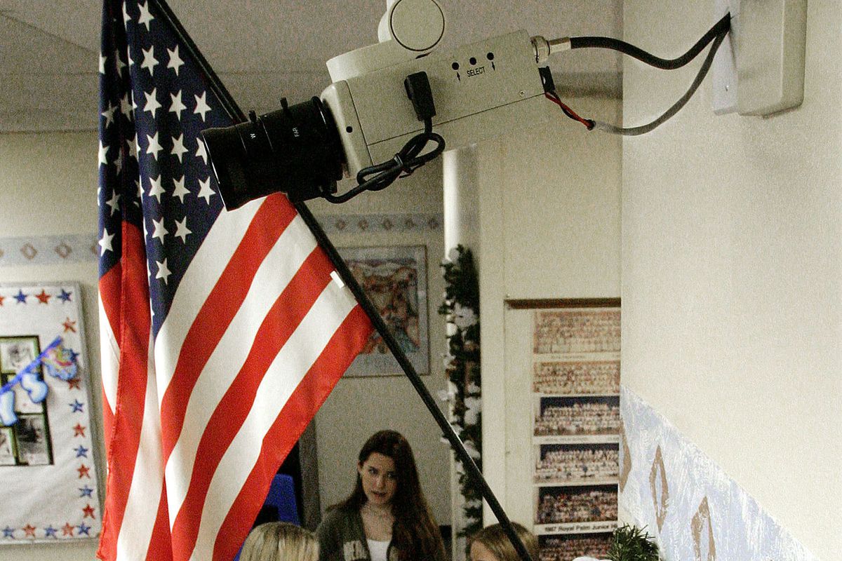 Students stand in a classroom beneath a US flag and near a facial-recogniton-enabled camera at a school in Phoenix, Arizona.