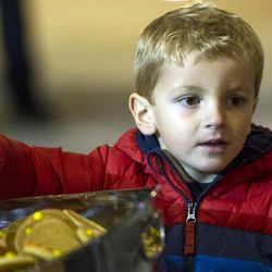 Oliver Belnap snags a couple of cookies while looking to his parents for approval during the annual lighting of the Christmas tree at The Gateway in Salt Lake City on Saturday, Nov. 19, 2016. Participants drank hot chocolate and ate cookies as they watched the tree shine for the first time this holiday season.