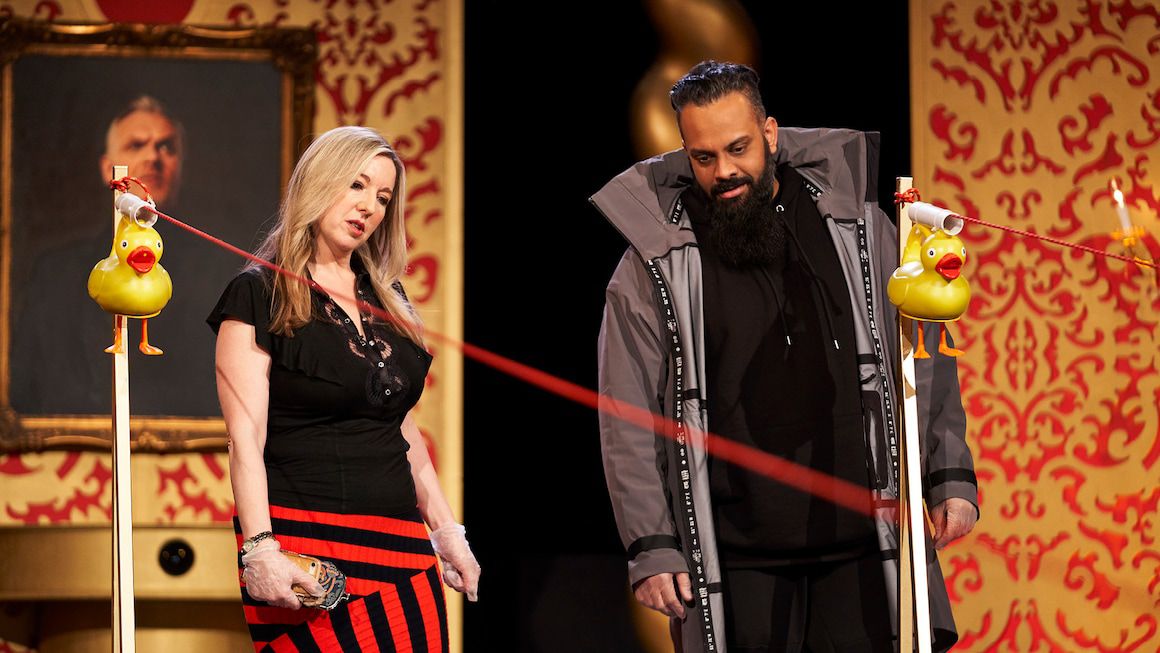 Victoria Coren Mitchell and Guz Khan look in confusion at an array of rubber ducks on strings in the Taskmaster studio.
