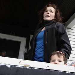 Patty Campbell speaks to reporters outside her home in Medford, Mass., Tuesday, April 16, 2013. Campbell's daughter, Krystle Campbell, was killed in Monday's bombings at the finish line of the Boston Marathon. The boy, lower right, is unidentified. 