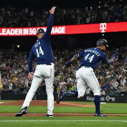SEATTLE, WASHINGTON - AUGUST 27: Julio Rodriguez #44 and third base coach Manny Acta #14 of the Seattle Mariners celebrate after Rodriguez’s solo home run during the third inning against the Cleveland Guardians at T-Mobile Park on August 27, 2022 in Seattle, Washington.