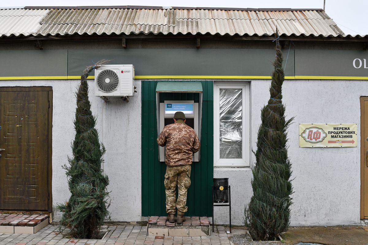Ukrainian army soldier seen at an ATM machine in Mayorske.