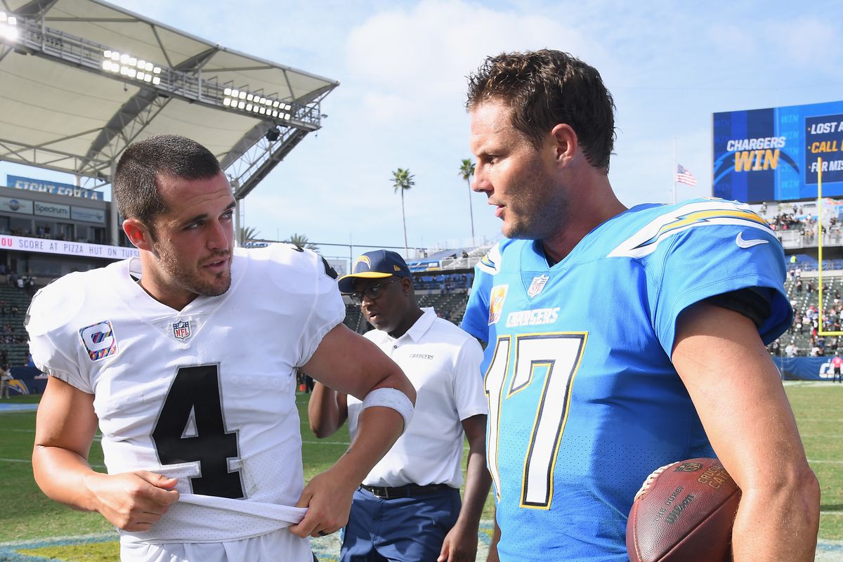 Derek Carr #4 of the Oakland Raiders and Philip Rivers #17 of the Los Angeles Chargers talk after a 26-10 Charger win at StubHub Center on October 7, 2018 in Carson, California.