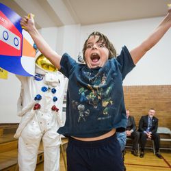 Ethan Jones, 9, jumps for joy after he peels off the last digit of a $1 million commitment from the Edward St. John Foundation toward a new space center and planetarium in Utah Valley at Central Elementary School in Pleasant Grove on Monday, Dec. 17, 2018.