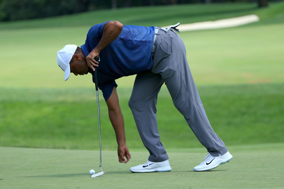 Tiger Woods of the United States reaches for his ball on the seventh green during the second round of The Memorial Tournament on July 17, 2020 at Muirfield Village Golf Club in Dublin, Ohio.