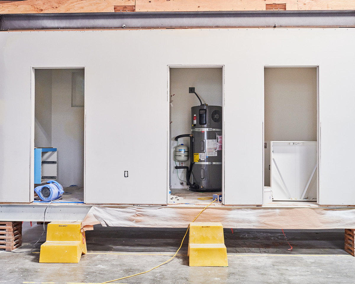 Three doorways lead to three rooms as tiny homes are being made.