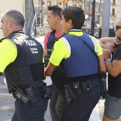 A woman is carried in Barcelona, Spain, Thursday, Aug. 17, 2017 after a white van jumped the sidewalk in the historic Las Ramblas district, crashing into a summer crowd of residents and tourists and injuring several people, police said.