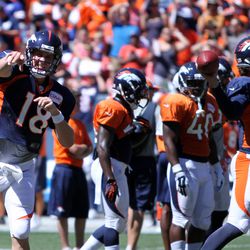 Broncos QBs Peyton Manning (L) and Brock Osweiler (R) throw passes during drills at the Broncos Summer Scrimmage