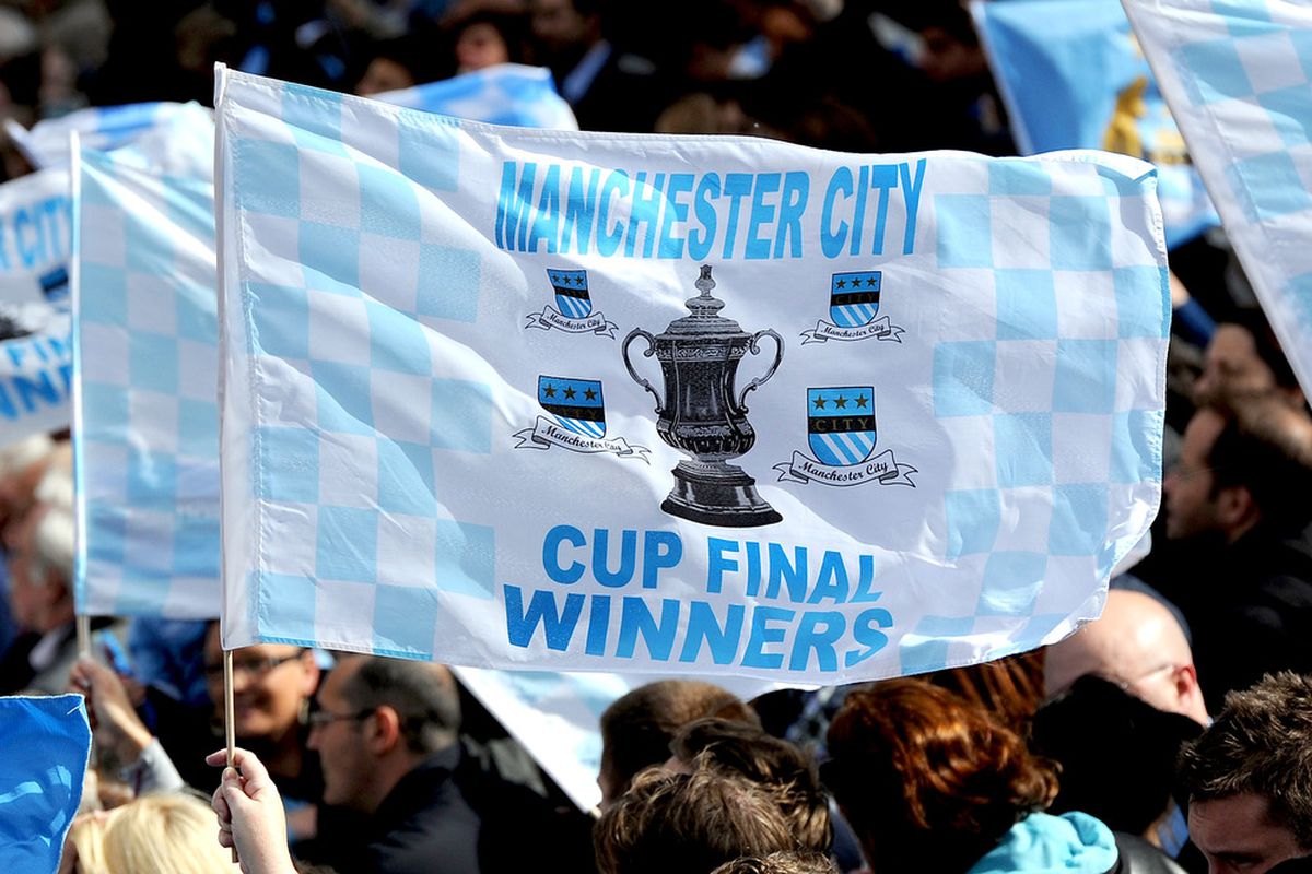 MANCHESTER, ENGLAND - MAY 23:  A Manchester City fan waves a flag during the Manchester City FA Cup Winners Parade at Manchester Town Hall on May 23, 2011 in Manchester, United Kingdom.  (Photo by Chris Brunskill/Getty Images)