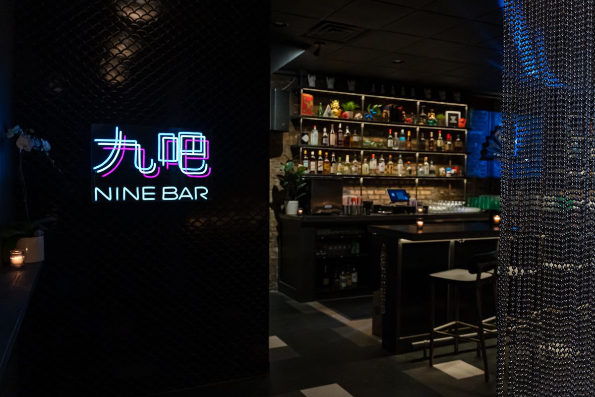 A dark basement bar with a neon sign.